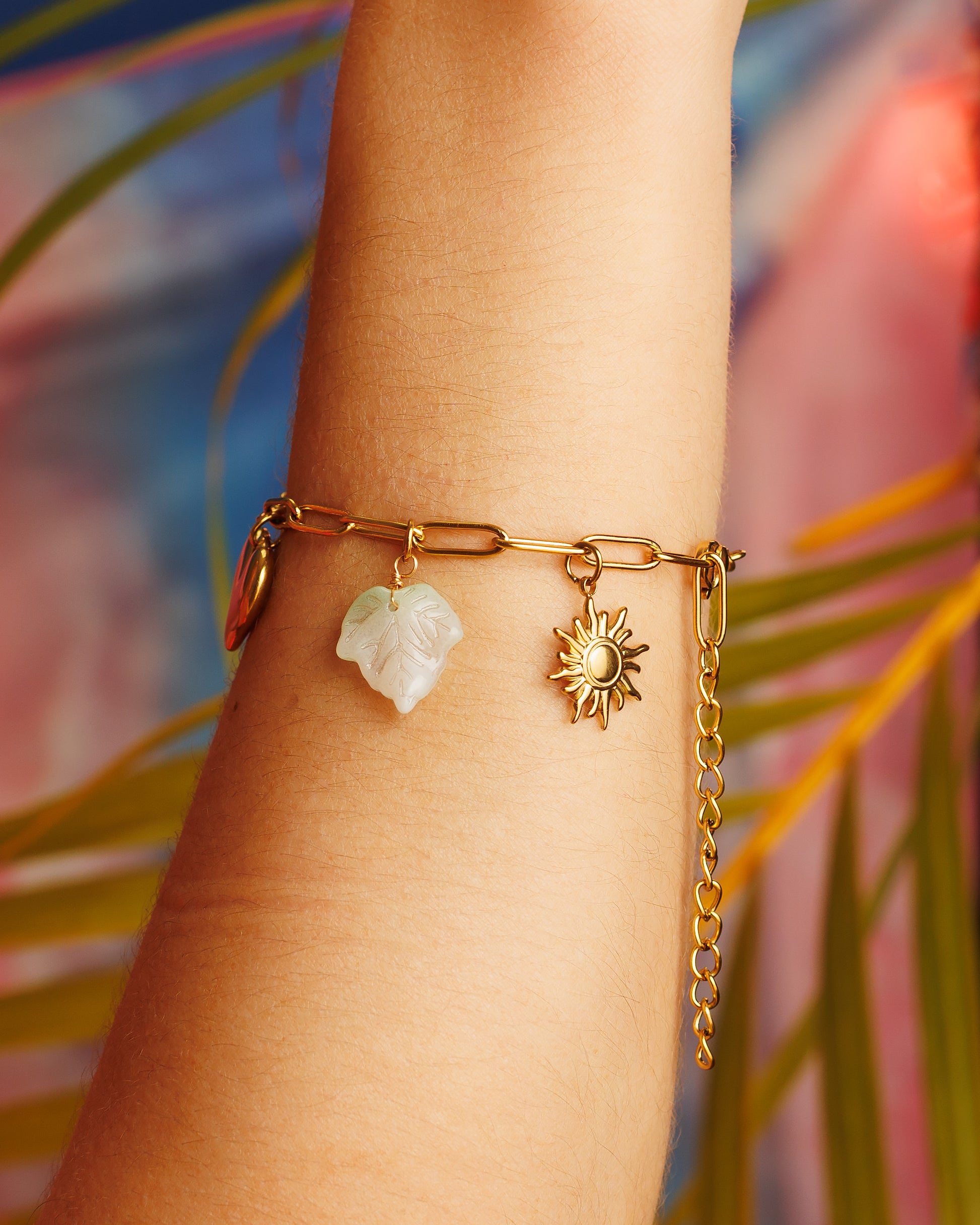 Pulsera de charms con lazo, sol, hoja, perla y corazón