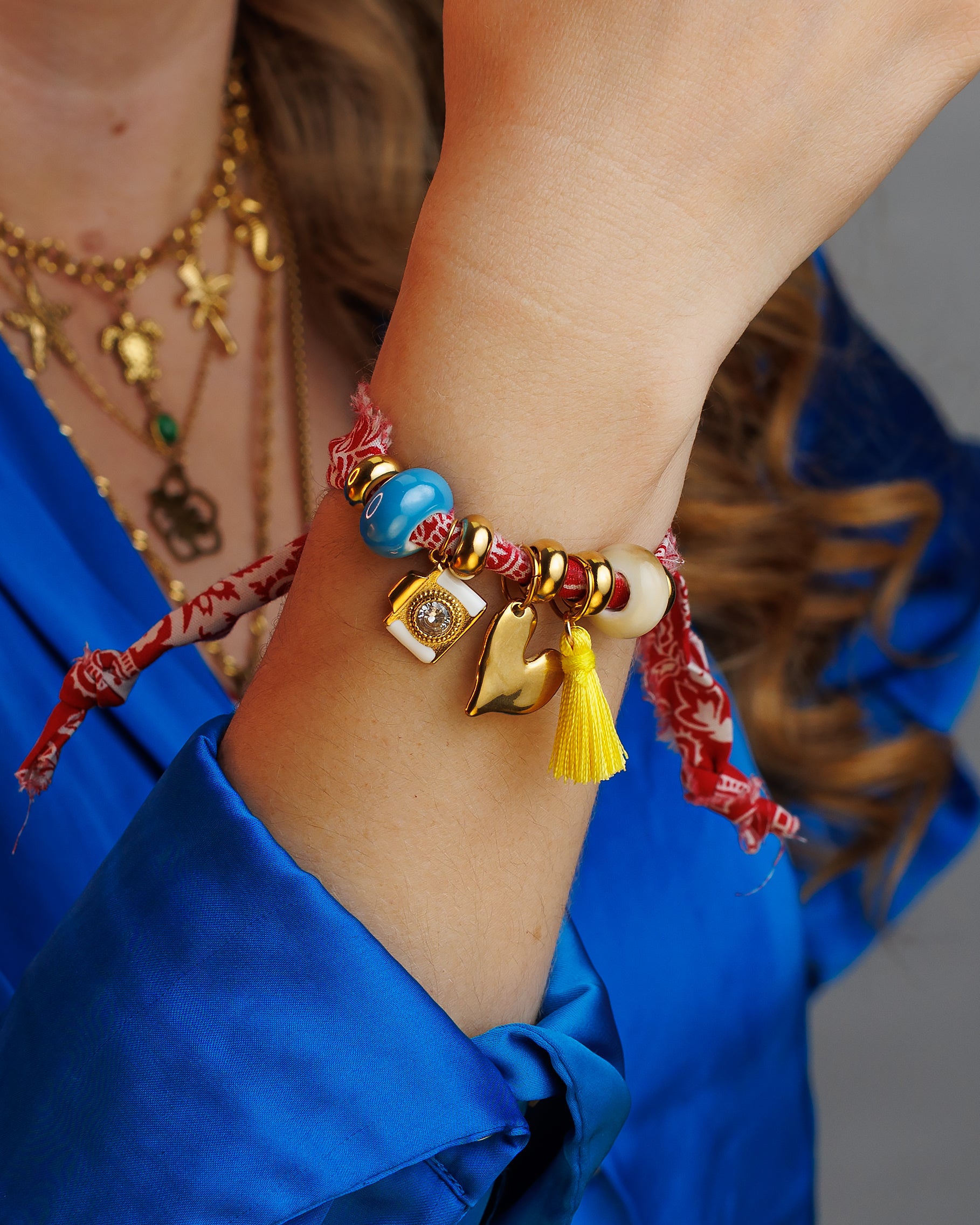 Pulsera de tela roja con cámara y corazón.