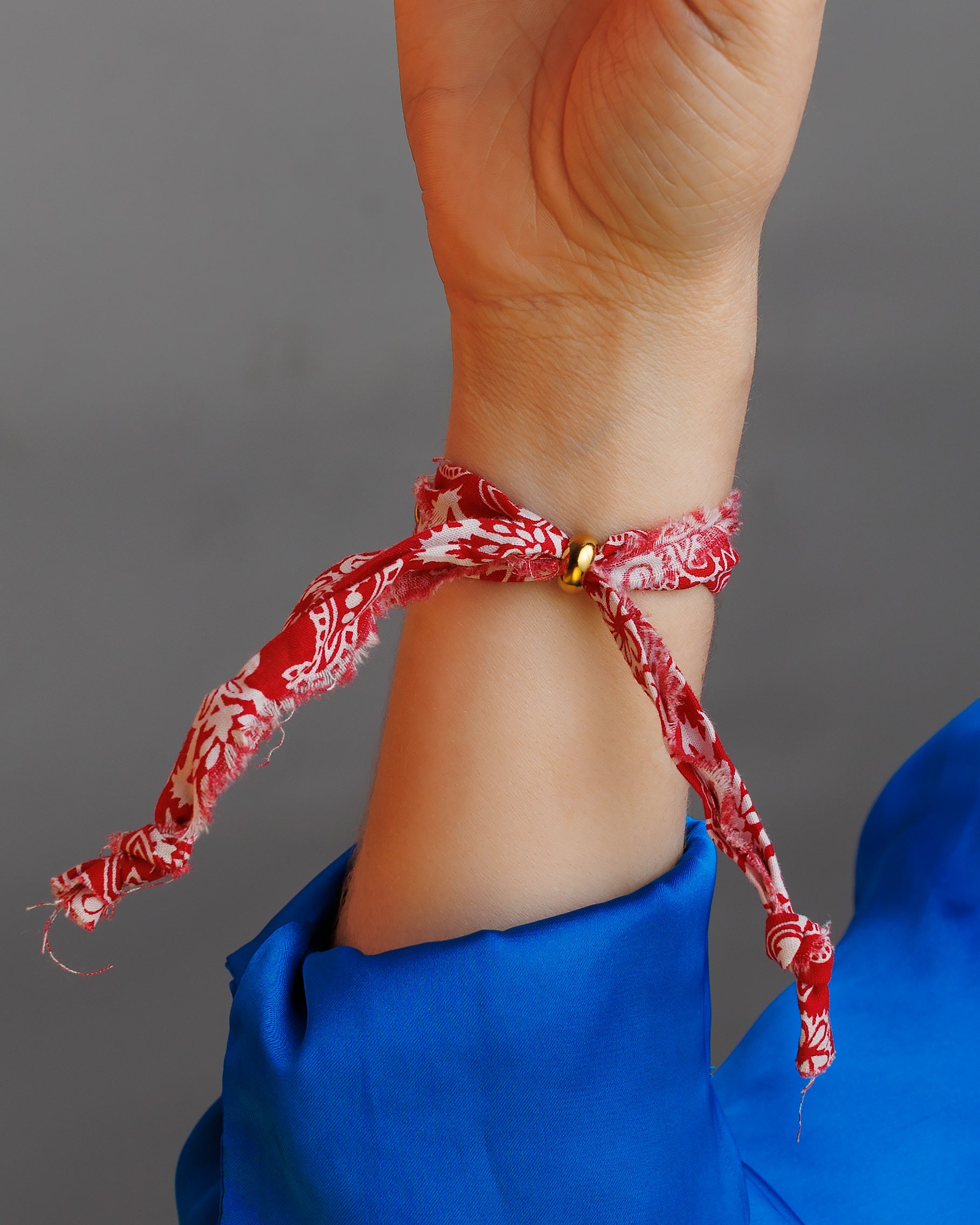 Pulsera de tela roja con cámara y corazón.
