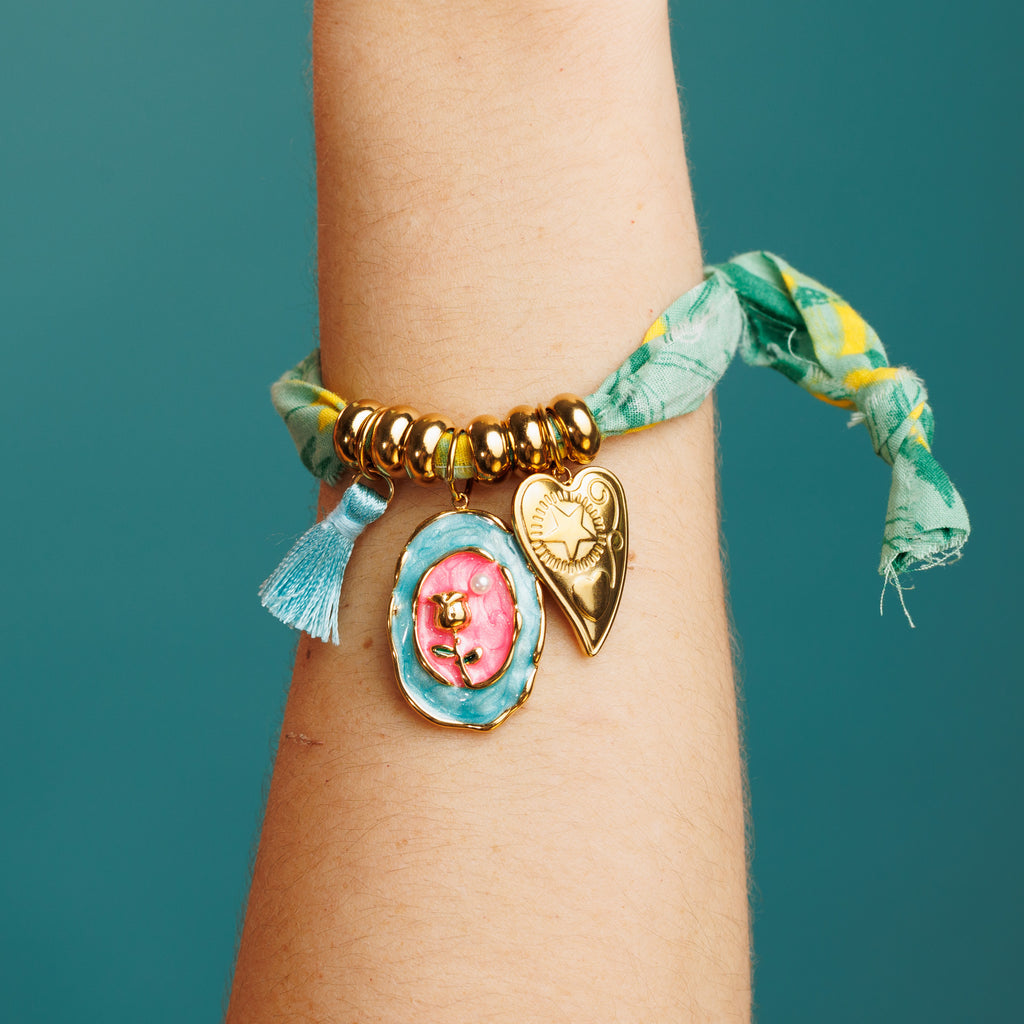 Pulsera de tela verde con charms de corazón, flor y hilo